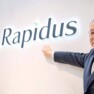 Chefe da Rapidus ao lado da logo da empresa
